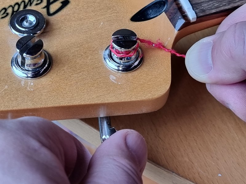 Fender Jazz bass. After locating the string in the hole in the base of the tuning peg start winding